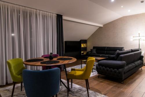 uma sala de estar com mesa e cadeiras em Apart Hotel Maksimum em Belgrado