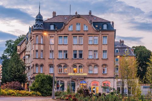 un grand bâtiment en briques en face d'une rue dans l'établissement Hôtel Le Mondon Metz, à Metz