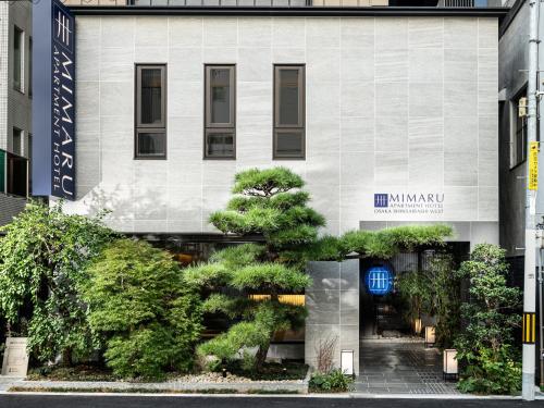 a building with trees in front of it at MIMARU Osaka Shinsaibashi West in Osaka