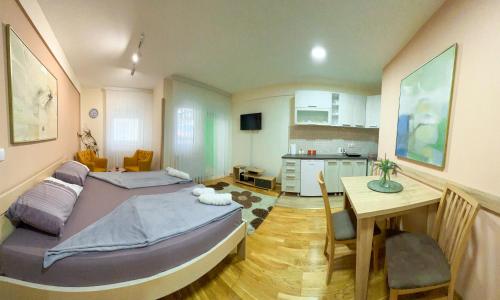 um quarto com 2 camas, uma mesa e uma cozinha em Yeni Pazar em Novi Pazar