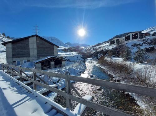 einen Fluss vor einer Scheune im Schnee in der Unterkunft Corn Alv 13 in Bivio