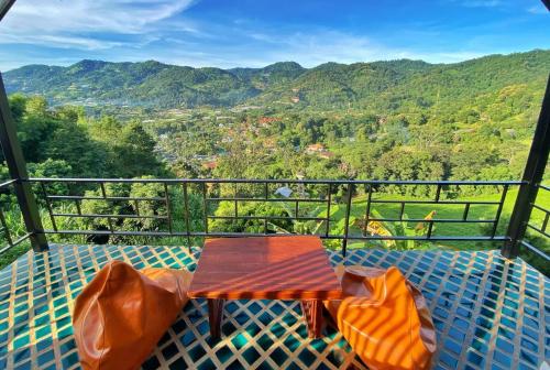 d'une table sur un balcon avec vue sur les montagnes. dans l'établissement Bann Suan Maya, à Mae Rim