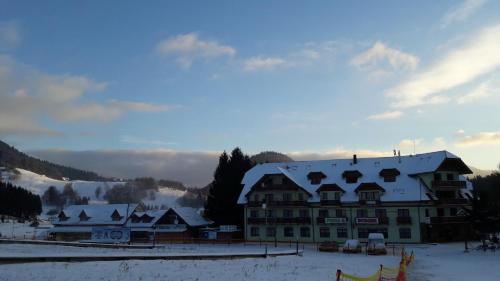 a large building with a snow covered roof in the snow at Aparmánový dom Kamzík,Apartmán 42,Donovaly in Donovaly