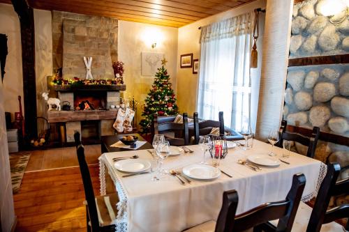 a dining room with a table and a christmas tree at Velinov Boutique Hotel in Bansko