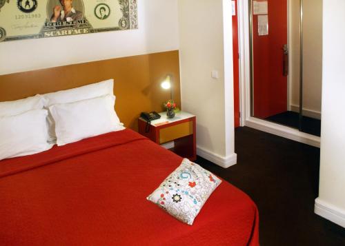 una camera con un letto rosso e una coperta rossa di Hotel Joao XXI a Braga