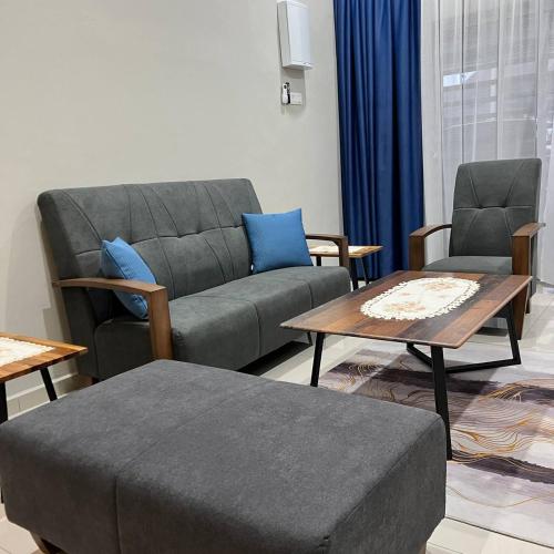 a living room with a couch and two chairs and a table at Homestay Ayer Keroh Tasik Utama in Ayer Keroh