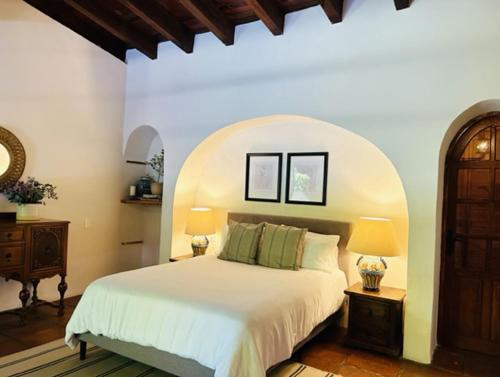 1 dormitorio con cama blanca y techo abovedado en Villa Tatala hotel boutique, en Tepoztlán