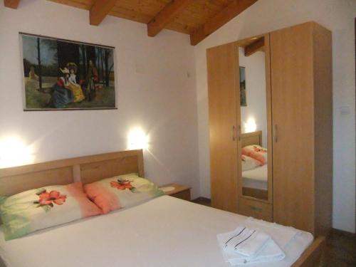 a bedroom with a bed and a large mirror at Apartments Ivanković in Stari Grad