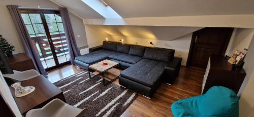 ein Wohnzimmer mit einem Sofa und einem Tisch in der Unterkunft Apartman Deluxe villa Barbora Hrabovo in Ružomberok