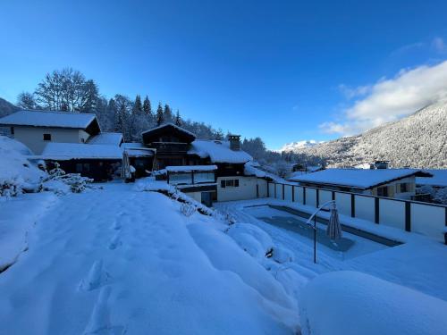 ein schneebedeckter Hof mit einem Haus in der Unterkunft Chalet Galadhrim Chamonix Mont Blanc Valley in Les Houches