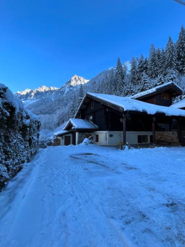 eine schneebedeckte Straße vor einem Gebäude in der Unterkunft Chalet Galadhrim Chamonix Mont Blanc Valley in Les Houches