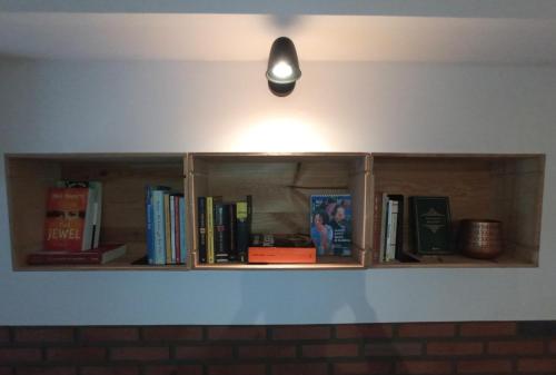 uma prateleira com livros e uma luz na parede em Volt76 - Como lake apartment em Como