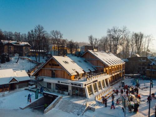 Eine Gruppe von Menschen, die im Schnee durch ein Gebäude laufen in der Unterkunft Willa Pod Kolejką in Szczawnica