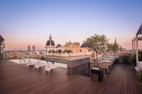 d'un balcon avec des chaises blanches et une vue sur la ville. dans l'établissement Ohla Barcelona, à Barcelone