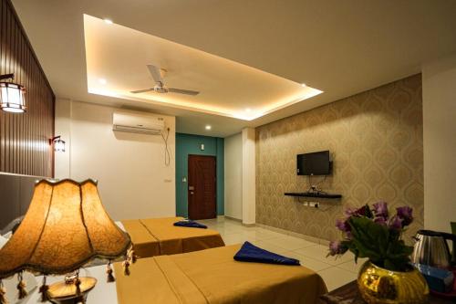 a hotel room with two beds and a tv at Melanna Cherai Beach Resorts in Cherai Beach