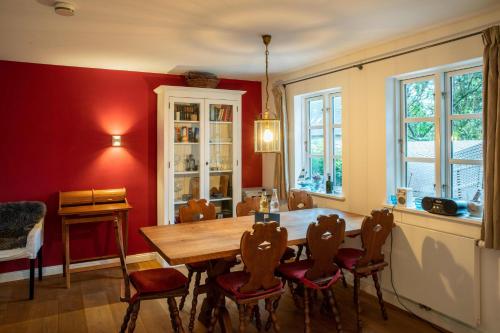 a dining room with a wooden table and chairs at Ferienwohnung Abelke in Utersum