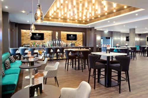 ein Restaurant mit Tischen und Stühlen und eine Bar in der Unterkunft Sandman Signature London Gatwick Hotel in Crawley