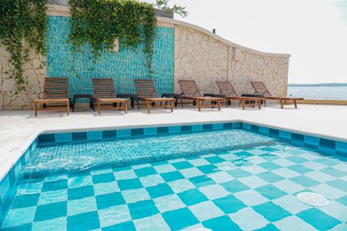 a swimming pool with chairs and a table and a pool at Hotel Caribbean Cartagena in Cartagena de Indias