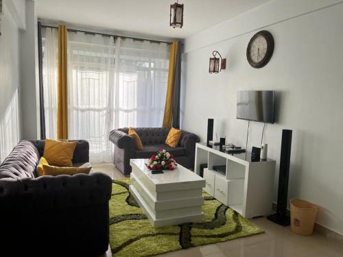 ein Wohnzimmer mit 2 Sofas und einem Tisch in der Unterkunft Zoe Homes Greypoint 1br and 2br Apartment 101 in Kericho