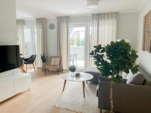 un soggiorno con divano e tavolo con piante di Ferienwohnung Swedish Summer a Scharbeutz