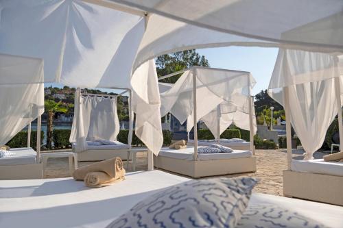 a group of four beds under a white canopy at TUI BLUE Kalamota Island - Adults Only in Dubrovnik