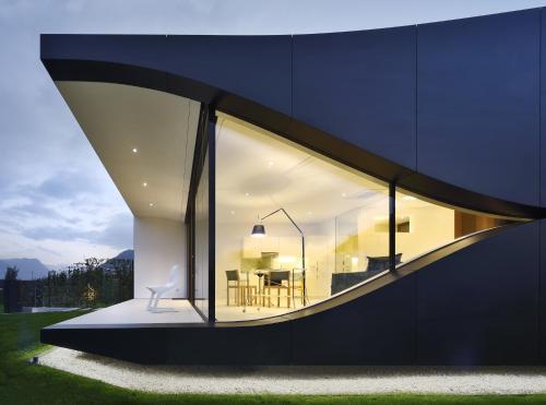 uma casa com uma grande janela do lado em Mirror Houses em Bolzano