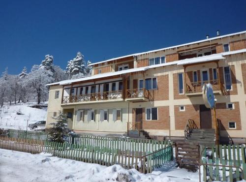 un edificio con una recinzione nella neve di Hotel Apollon a Bakuriani