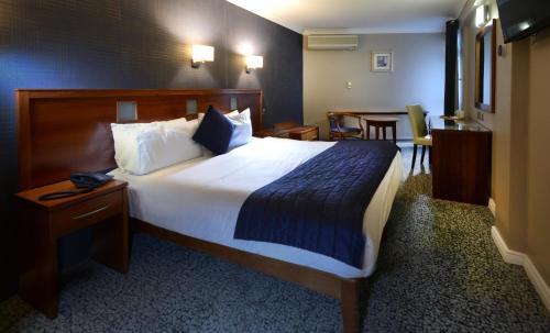 a hotel room with a large bed and a table at Imperial Hotel Galway in Galway