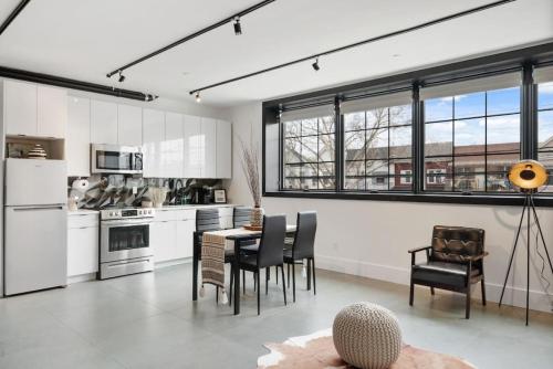 布鲁克林Deluxe Open Concept Loft with Rooftop & Shore Nearby at "Brooklyn Bay Lofts"的厨房配有白色橱柜和桌椅