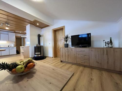 uma sala de estar com televisão e uma taça de fruta em apartment Eva in Wald im Pinzgau with balcony em Wald im Pinzgau