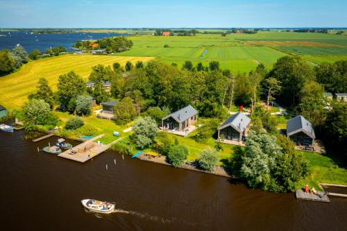 une vue aérienne sur une île dans l'eau avec des maisons dans l'établissement Pean-buiten Waterlodges, à Nes