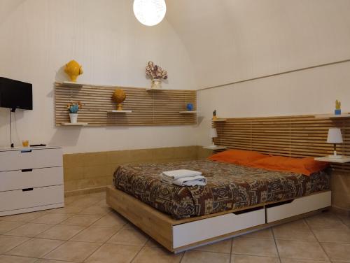 a bedroom with a bed and a television in it at Dimora Dioniso in Polignano a Mare