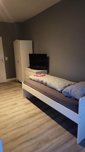 1 dormitorio con 1 cama y vestidor con nevera en Flensburg Strandnah, en Flensburg