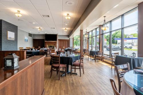 a dining room with tables and chairs and windows at Glengarry Extended Stays in Truro