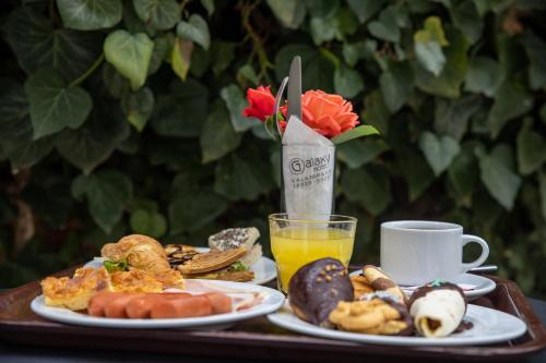 een tafel met twee borden eten en een kop sinaasappelsap bij Hotel Galaxy in Kalabaka