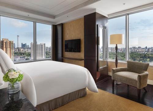 una camera da letto con un grande letto bianco e una grande finestra di Four Seasons Hotel Beijing a Pechino