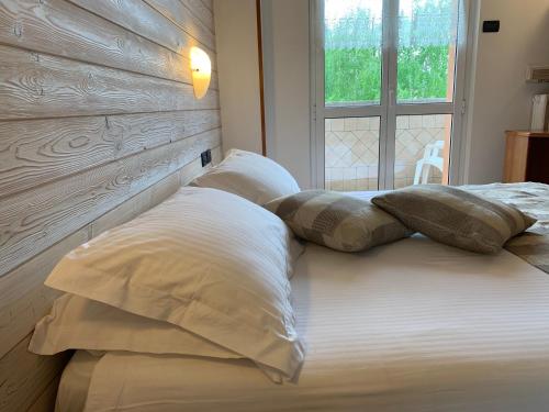 ein Bett mit zwei Kissen und einem Fenster in der Unterkunft Albergo Moderno & Spa in Fuipiano Valle Imagna