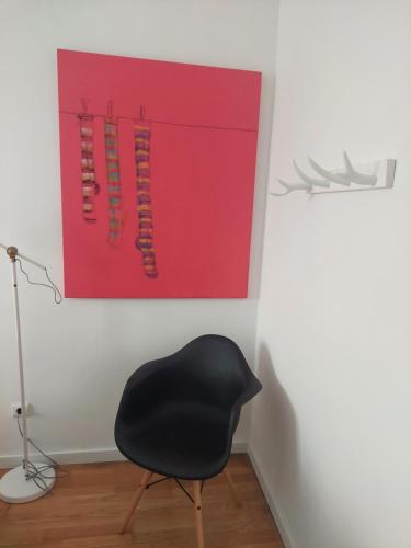 a black chair in a room with a painting at GALLE - Apartamento dos Infantes in Beja