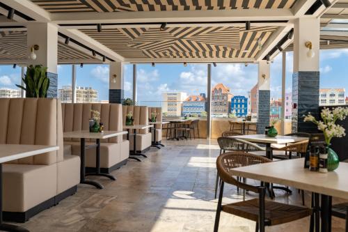 un restaurant avec des tables et des chaises et une vue sur la ville dans l'établissement Harbor Hotel & Casino Curacao, à Willemstad