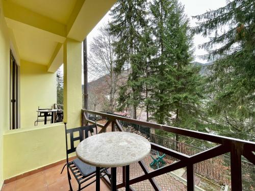 un tavolo e sedie su un balcone con vista di Vila Condor a Poiana Brasov