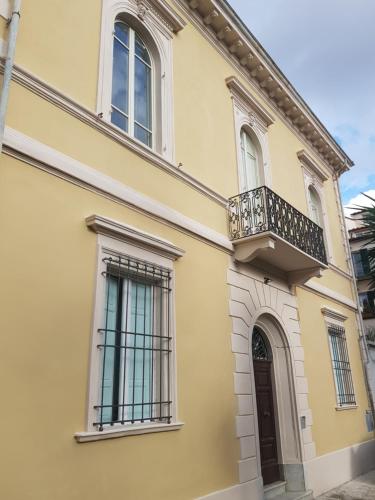 gelbes Haus mit Balkon und Tür in der Unterkunft PALACE COMFORT INN in Pisa