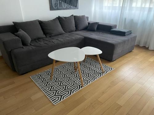 uma sala de estar com um sofá e uma mesa em Apartment IRIS em Novi Sad