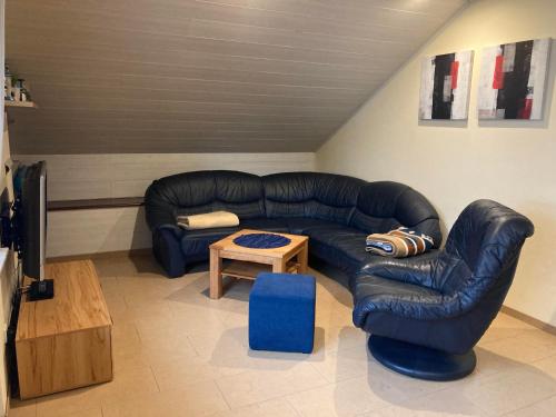 a living room with a black leather couch and a table at Ferienwohnung "Casa Horife" in Konz