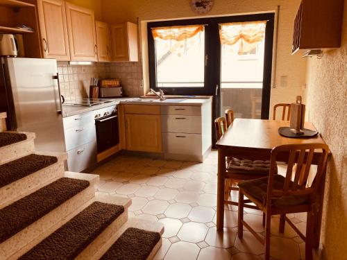 a kitchen with a table and a refrigerator at Ferienwohnung "Casa Horife" in Konz