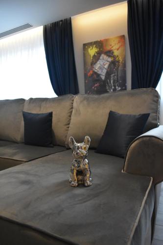 eine kleine Hundefigurin, die auf einer Couch sitzt in der Unterkunft Omnia Apartments in Iaşi