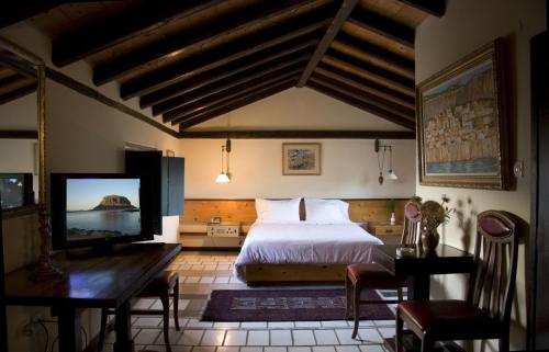 - une chambre avec un lit et une télévision à écran plat dans l'établissement Lazareto Hotel, à Monemvasia