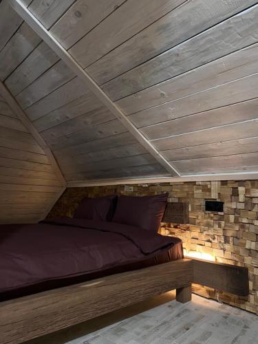 a bed in a room with a wooden ceiling at Luxury Live in Kamianets-Podilskyi