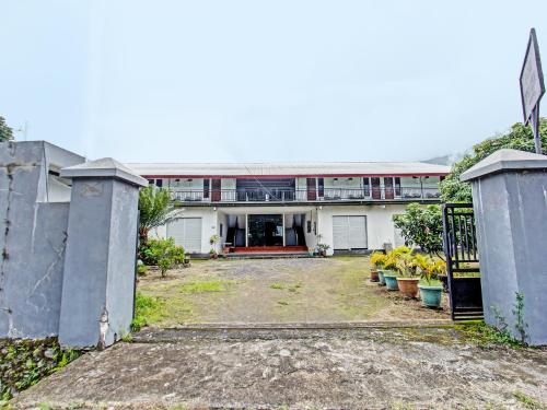 a large white building with a gate and some plants at OYO 92090 Panorama Rinjani Lodge in Labuan Lombok