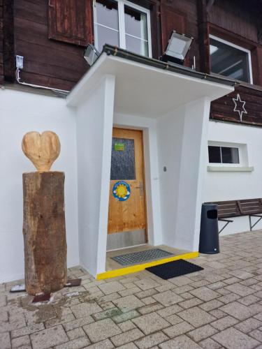 un piccolo edificio bianco con una porta in legno di Ferienhaus Davos "Ob dem See" a Davos