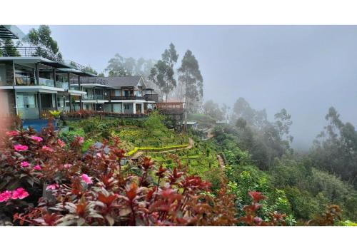 una casa sul fianco di una collina con dei fiori di Chandys Drizzle Drops - Munnar Top Station a Munnar